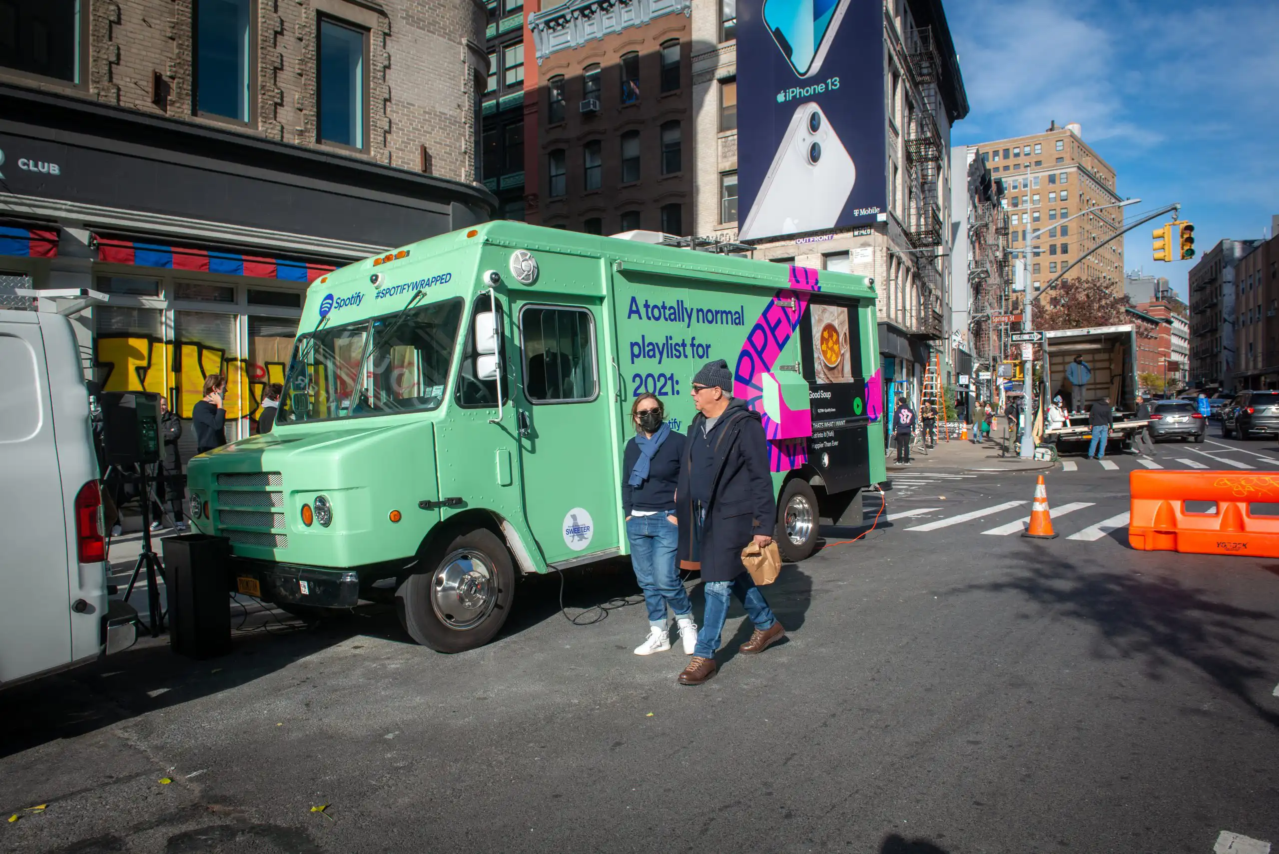 Kim and Grant walking next to food truck promotion for Spotify